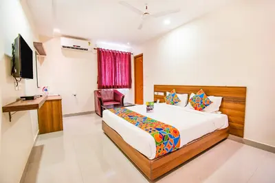 a bedroom with a bed and a desk and a television at FabHotel Thejas Paaradise - Nr Coimbatore Institute of Technology in Coimbatore