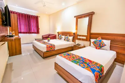 a hotel room with two beds and a mirror at FabHotel Thejas Paaradise - Nr Coimbatore Institute of Technology in Coimbatore