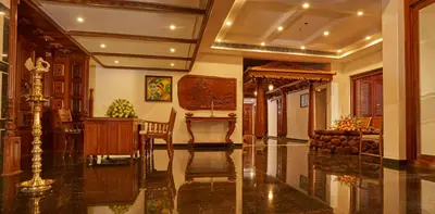 a lobby with a table and a chair in a building at Sterling Guruvayur in Guruvāyūr