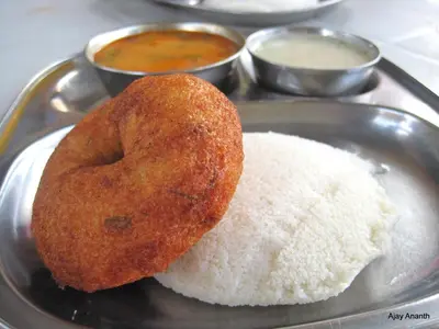 two donuts sitting on a plate with rice at Sterling Guruvayur in Guruvāyūr