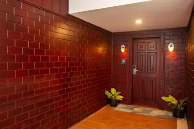 a brick hallway with a red brick wall and a door at Coorg Cliffs Resorts in Ammatti