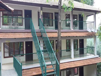 a building with a green staircase in front of it at Coorg Cliffs Resorts in Ammatti