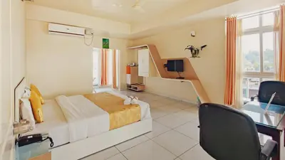 a bedroom with a bed and a desk and a tv at The Cocoon in Gonikoppal