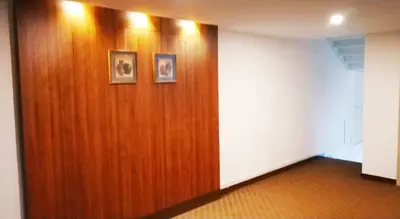 a wooden wall in a room with two pictures on it at Alhind Calicut Tower in Kozhikode