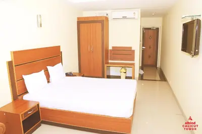 a bedroom with a large bed and a television at Alhind Calicut Tower in Kozhikode