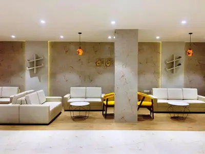 a living room with white couches and tables at Alhind Calicut Tower in Kozhikode