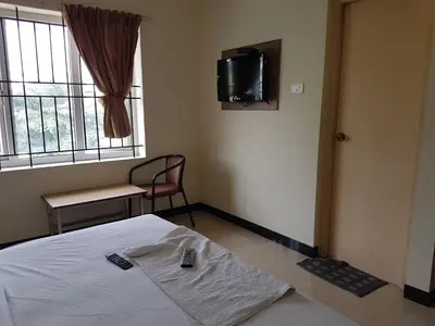 a room with a bed and a tv on the wall at SK Residency in Coimbatore