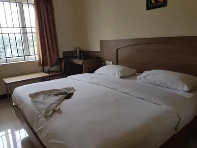 a hotel room with a bed with a towel on it at SK Residency in Coimbatore