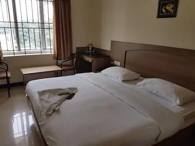 a bedroom with a bed with a robe on it at SK Residency in Coimbatore