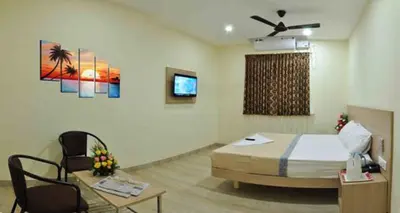 a room with a bed and a table and a tv at SK Residency Unit 2 in Coimbatore