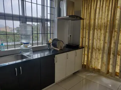 a kitchen with a sink and a counter with a window at Suvarna Compact in Mysore