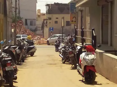 a row of motorcycles parked on the side of a street at Suvarna Compact in Mysore