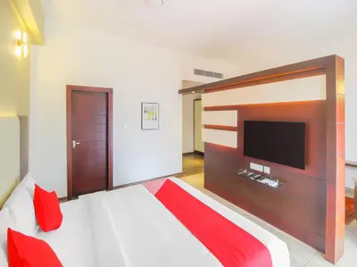 a bedroom with a large bed with a flat screen tv at Samudra Mysore in Mysore
