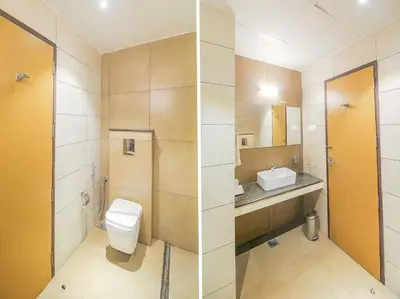 a bathroom with a toilet and a sink at Samudra Mysore in Mysore