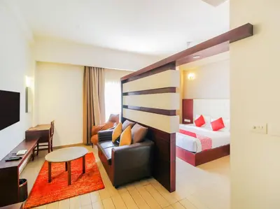 a hotel room with a couch and a bed at Samudra Mysore in Mysore