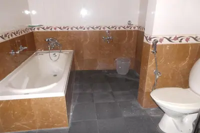 a bathroom with a tub and a toilet and a sink at Hotel Span in Kozhikode