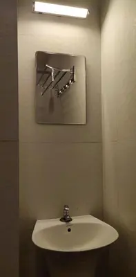 a bathroom with a white sink and a mirror at Hotel Green Plaza in Trichūr