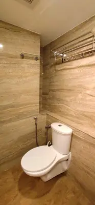 a bathroom with a white toilet in a room at Hotel Green Plaza in Trichūr