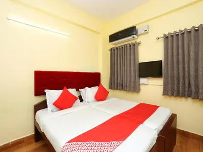 a bedroom with a large bed with red pillows at Hotel Green Plaza in Trichūr