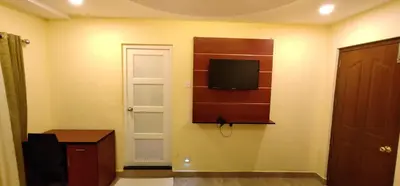 a room with a flat screen tv on a wall at Hotel Green Plaza in Trichūr