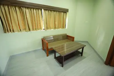a small room with a table and a window at Haksons Residency in Mananthavady