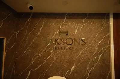 a sign on a marble wall in a hotel room at Haksons Residency in Mananthavady