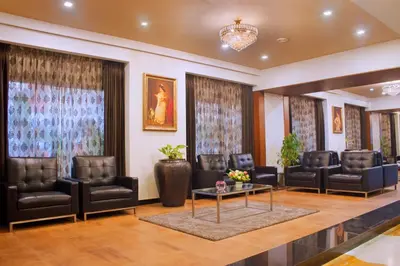 a waiting room with leather chairs and a table at President Hotel in Mysore