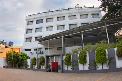 a white building with plants on the side of it at President Hotel in Mysore