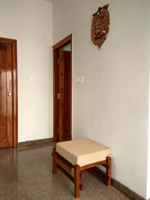 a bench sitting in the corner of a room at Aashraya Homestay in Mysore
