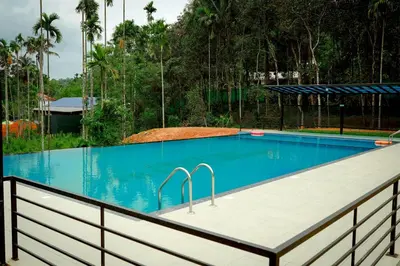a swimming pool with a fence around it at Century Village Resort in Mananthavady
