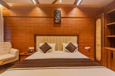 a bedroom with a bed and a chair at The Nest Inn Resort in Masinagudi