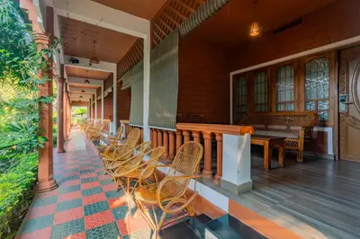 a row of chairs and a table on a porch at The Nest Inn Resort in Masinagudi