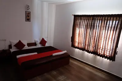 a bedroom with a bed and a large window at Rosepark Residency in Ooty