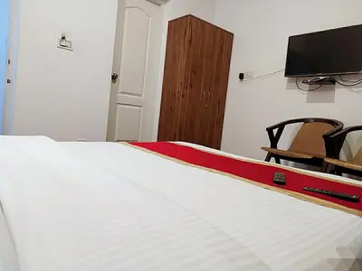 a bedroom with a bed and a flat screen tv at Rosepark Residency in Ooty