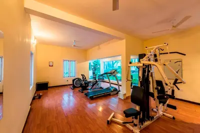 a gym with several treadmills and machines in a room at Royal Orchid Metropole Mysore in Mysore