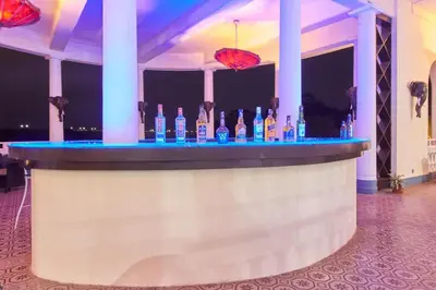 a bar with a bunch of bottles of booze at Royal Orchid Brindavan Garden Palace & Spa Mysore in Belagula