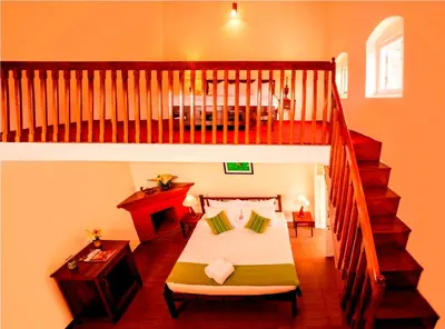 a room with a bed and a staircase with a stair case at Teanest Nightingale by Nature Resorts and Stays in Kotagiri