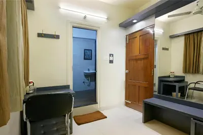 a bathroom with a sink and a toilet and a mirror at Mannars Deluxe Lodge in Mysore