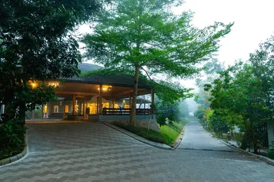 a house with a tree in the middle of a driveway at Sterling Wayanad in Sultan Bathery