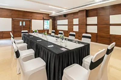 a conference room with a long table and white chairs at Sterling Wayanad in Sultan Bathery