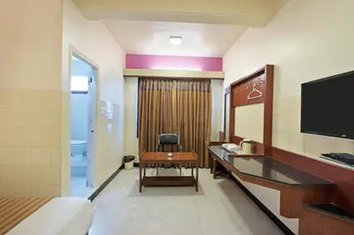 a hotel room with a desk and a television at Mannars Yatri Nivas Hotel in Mysore