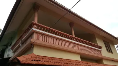 a building with a balcony on the side of it at Wayanad Homestay in Kalpetta