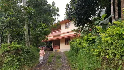 a little girl walking in front of a house at Wayanad Homestay in Kalpetta