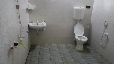 a bathroom with a toilet and a sink at Wayanad Homestay in Kalpetta