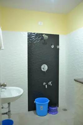a bathroom with a sink and a toilet and a shower at Golden Nest in Mysore