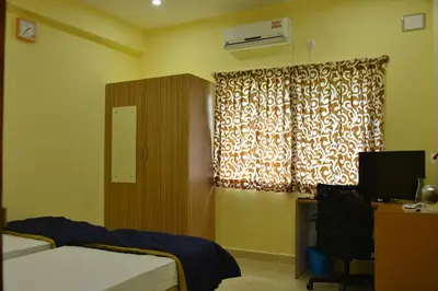 a bedroom with a bed and a window at Golden Nest in Mysore
