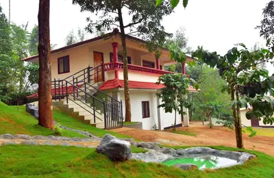 a house with a pond in front of it at Green Garden Deluxe Room in Vayittiri