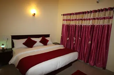 a bedroom with a bed with a red curtain at Green Garden Deluxe Room in Vayittiri