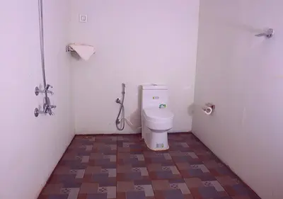 a small bathroom with a toilet in a stall at KOOMANKOLLY RESORT in Thirunelli