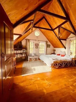 a bedroom with a large bed in a attic at Stumpfields in Ooty